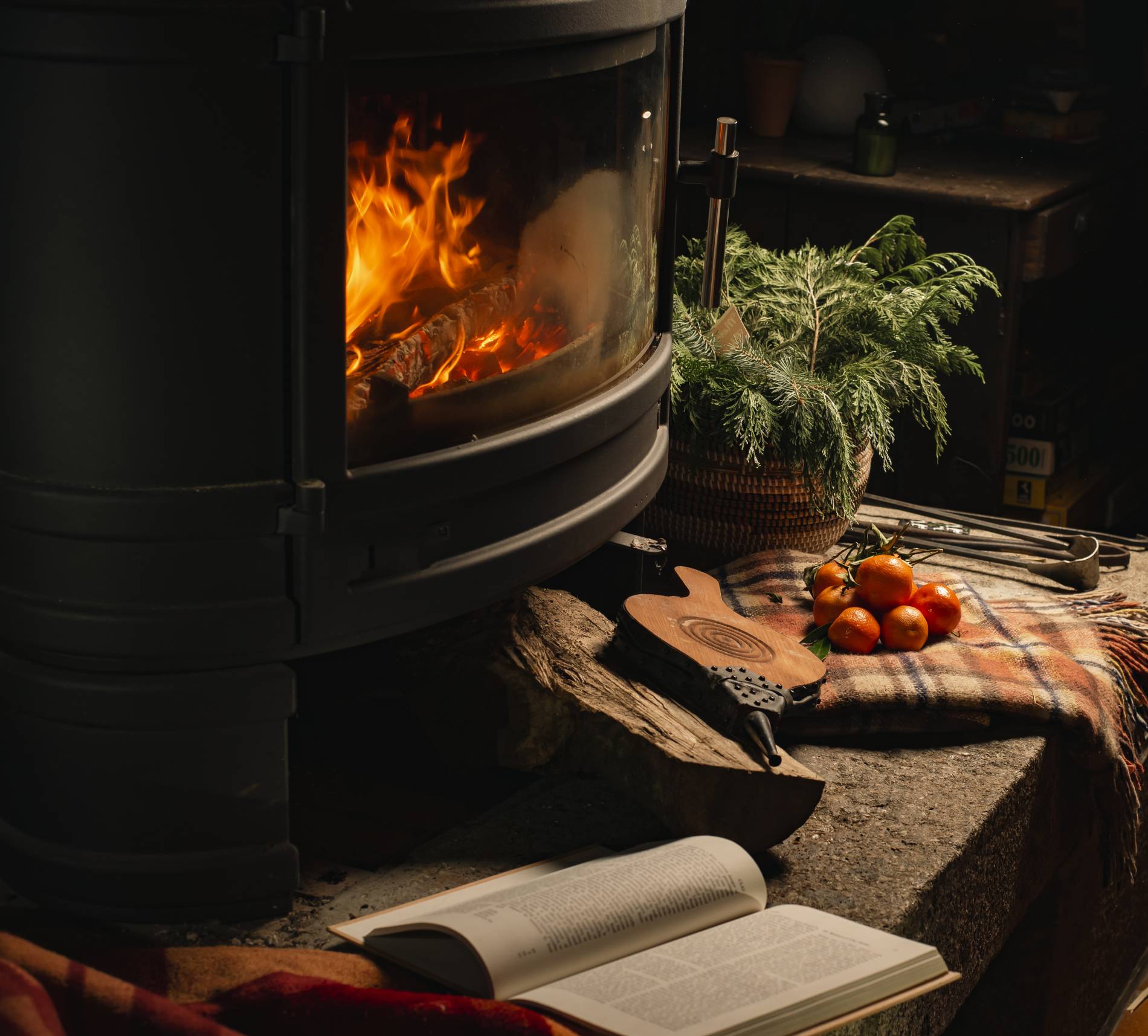 burning fireplace in a dark room with tangerines, plaid couverture